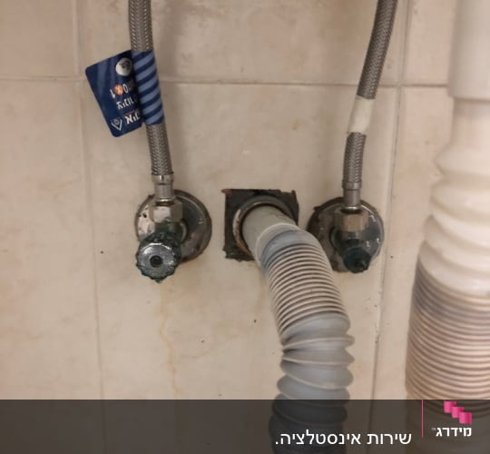 צינורות מים מחוברים לקיר עם ברזים
